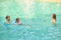 Parents teaching theri daughter to swim and looking involved