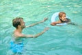 Parents teaching theri daughter to swim and looking involved