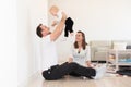 Parents and their beautiful baby girl sitting on the ground and playing. Royalty Free Stock Photo