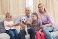 Parents with their children on sofa playing with puppy Royalty Free Stock Photo