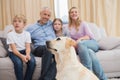 Parents and their children on sofa with puppy Royalty Free Stock Photo