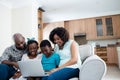 Parents and their children using laptop in living room Royalty Free Stock Photo