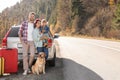Parents, their daughter and dog near car outdoors, space for text. Family traveling with pet Royalty Free Stock Photo
