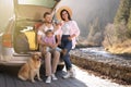 Parents, their daughter and dog near car outdoors, space for text. Family traveling with pet Royalty Free Stock Photo