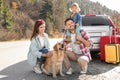 Parents, their daughter and dog near road. Family traveling with pet Royalty Free Stock Photo