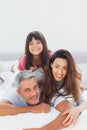 Parents with their daughter lying on bed Royalty Free Stock Photo