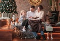 Parents with their young children sitting in the living room decorated for Christmas Royalty Free Stock Photo