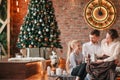 parents with their young children sitting in the living room decorated for Christmas Royalty Free Stock Photo