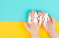 Parents with two child holding hands, family life, paper cut out, copy space, yellow and blue colored background, relationships Royalty Free Stock Photo