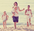 Parents with two kids jogging on beach Royalty Free Stock Photo