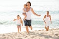 Parents with two kids jogging on beach Royalty Free Stock Photo