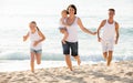 Parents with two kids jogging on beach Royalty Free Stock Photo