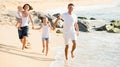 parents with two kids jogging on beach . Royalty Free Stock Photo