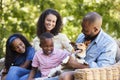 Parents and two kids sitting with pet dog in the garden Royalty Free Stock Photo
