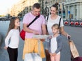 parents with two kids traveling together searching location on paper map