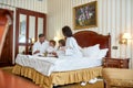 First, we eat, then we do everything else. Parents and two kids in white bathrobes talking while having breakfast in bed Royalty Free Stock Photo