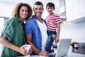 Parents using laptop with son in kitchen Royalty Free Stock Photo