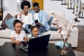 Parents using mobile while daughters playing on laptop Royalty Free Stock Photo