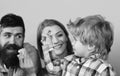 Parents watch kid playing with yellow and blue bricks. Man with beard, woman and boy play on blue background Royalty Free Stock Photo