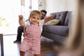 Parents Watching Baby Daughter Take First Steps At Home Royalty Free Stock Photo