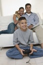 Parents Watching Son Play Video Games in living room front view Royalty Free Stock Photo