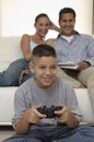 Parents Watching Son Play Video Games in living room front view Royalty Free Stock Photo