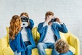 Parents wearing 3d glasses while sitting on sofa with their children