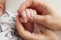 The hand of a mother and father close-up holds the fist of a newborn baby. Royalty Free Stock Photo