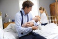 Parents With Young Baby Dressing For Work In Bedroom Royalty Free Stock Photo