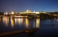 Pargue charles bridge and prague castle by night reflections river with boat motive in the front Royalty Free Stock Photo