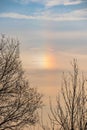 A parhelion (plural parhelia, sundog) - atmospheric optical phenomenon that consists of a bright colored spot in the sky Royalty Free Stock Photo