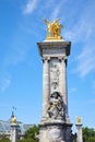 Paris, Alexandre III bridge golden statue with winged horse and column in a sunny day, blue sky