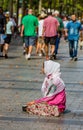 PARIS - AUGUST 10- An unidentified female begs on the street in the Champs-Elysees on August 10, 2015 in Paris, France.