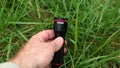 Male hand testing new mini Stier flashlight torch in green grass