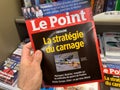 Man buys at press kiosk Le Point international newspaper magazine with dead