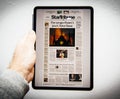 Man reading on iPad Pro about Notre-Dame de Paris fire