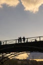 Tourists enjoy the warmth of spring, on a bridge of the Seine river in Paris.