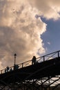 Tourists enjoy the warmth of spring, on a bridge of the Seine river in Paris.