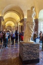 PARIS, FRANCE - APRIL 8, 2011: Visitors walking inside the Louvre near Venus de Milo statue Royalty Free Stock Photo