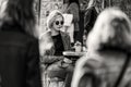 Grayscale natural shot of a beautiful lady with short hair and sunglasses sitting in a cafe