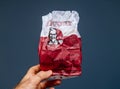 Man hand holding KFC meat paper bag with fresh delicious meat isolated on blue Royalty Free Stock Photo