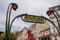 Paris, France. August 2022. The distinctive metropolitan sign with the Moulin Rouge in the background.