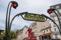Paris, France. August 2022. The distinctive metropolitan sign with the Moulin Rouge in the background.