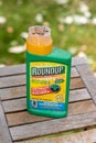 Paris, France - August 15, 2018 : Herbicide on a wooden table in a french garden. Roundup is a brand-name of an herbicide containi
