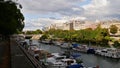 Beautiful view of tranquil Canal Saint-Martin with promenade, trees, docking boats and modern opera house Opera Bastille.