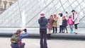 PARIS, FRANCE - DECEMBER, 31, 2016. Cheerful family posing and making photos near the Louvre, famous French museum