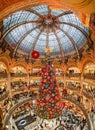 Paris, France - December 15: Massive Christmas tree decoration with flowers inside Galerie Layfayette shopping mall