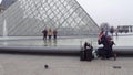 PARIS, FRANCE - DECEMBER, 31, 2016. Tourists posing and making photos near the Louvre, famous French museum. Popular