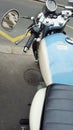 Paris, France. 02.29.2016. Details of an old motobike parked in the street with a light blue tank and a black seat. Royalty Free Stock Photo