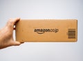 Man holding the side view of Amazon Japan prime cardboard